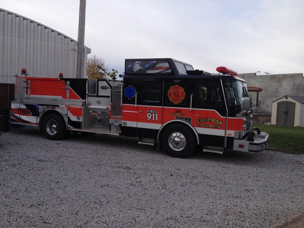 Large fire engine parked outside garage.