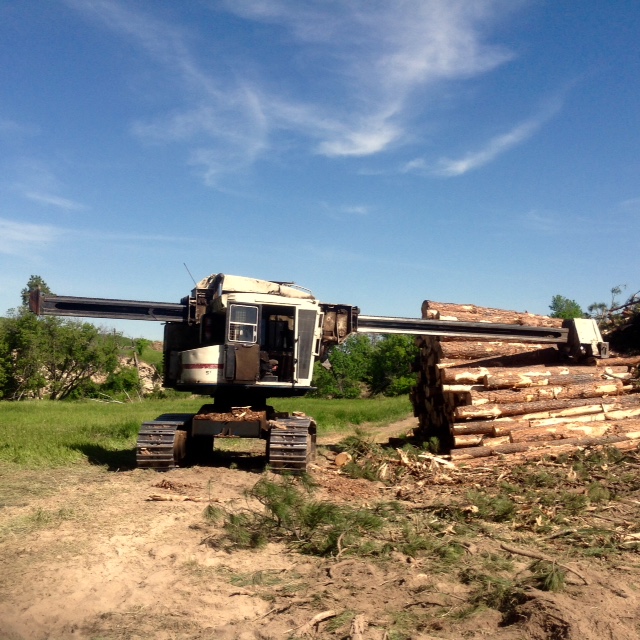Machine harvesting timber logs in Nebraska forest
