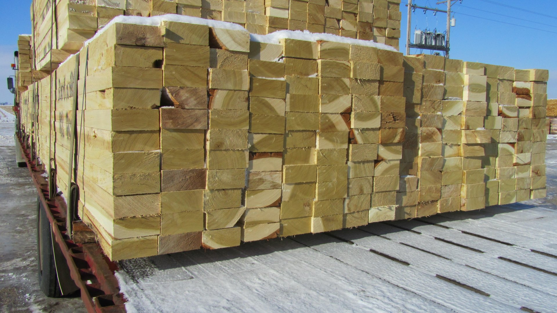  A pallet of rough sawn boards on a flatbed trailer.