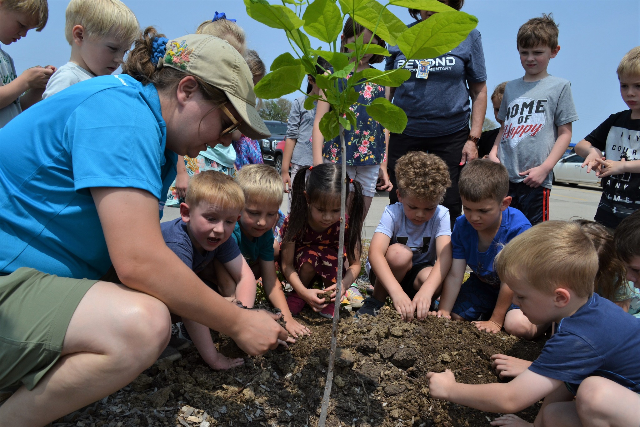 A photo of a forester holding a planting demonstration for kids