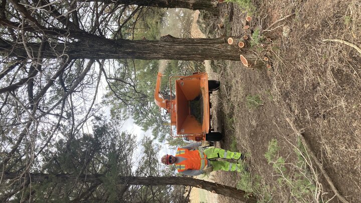 A photo of an inmate operating a wood chipper
