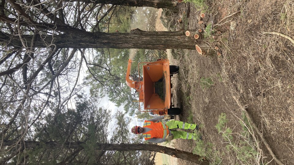 A photo of an inmate operating a wood chipper