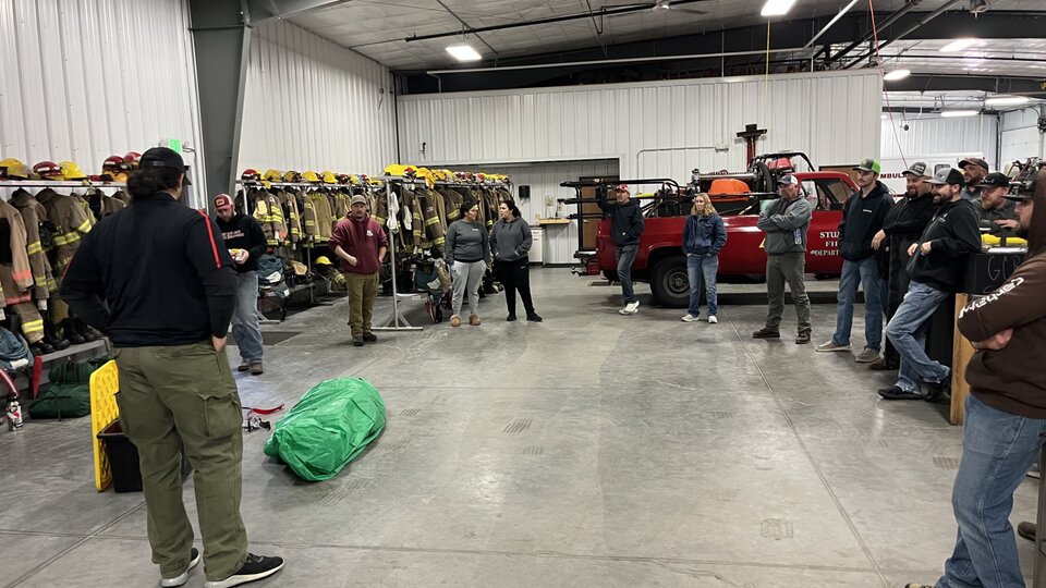 NFS Fire Instructor Dylan Owen begins to show students how to deploy a fire shelter