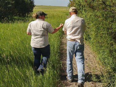 A photo of a forester walking with a landowner